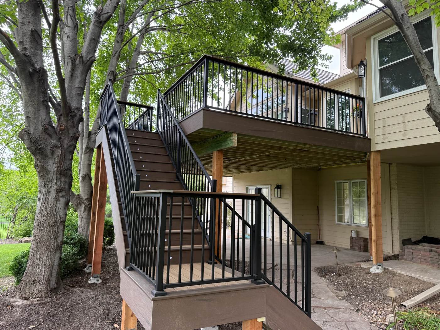 Custom cedar deck with black metal railing and stairs on a suburban home in Omaha